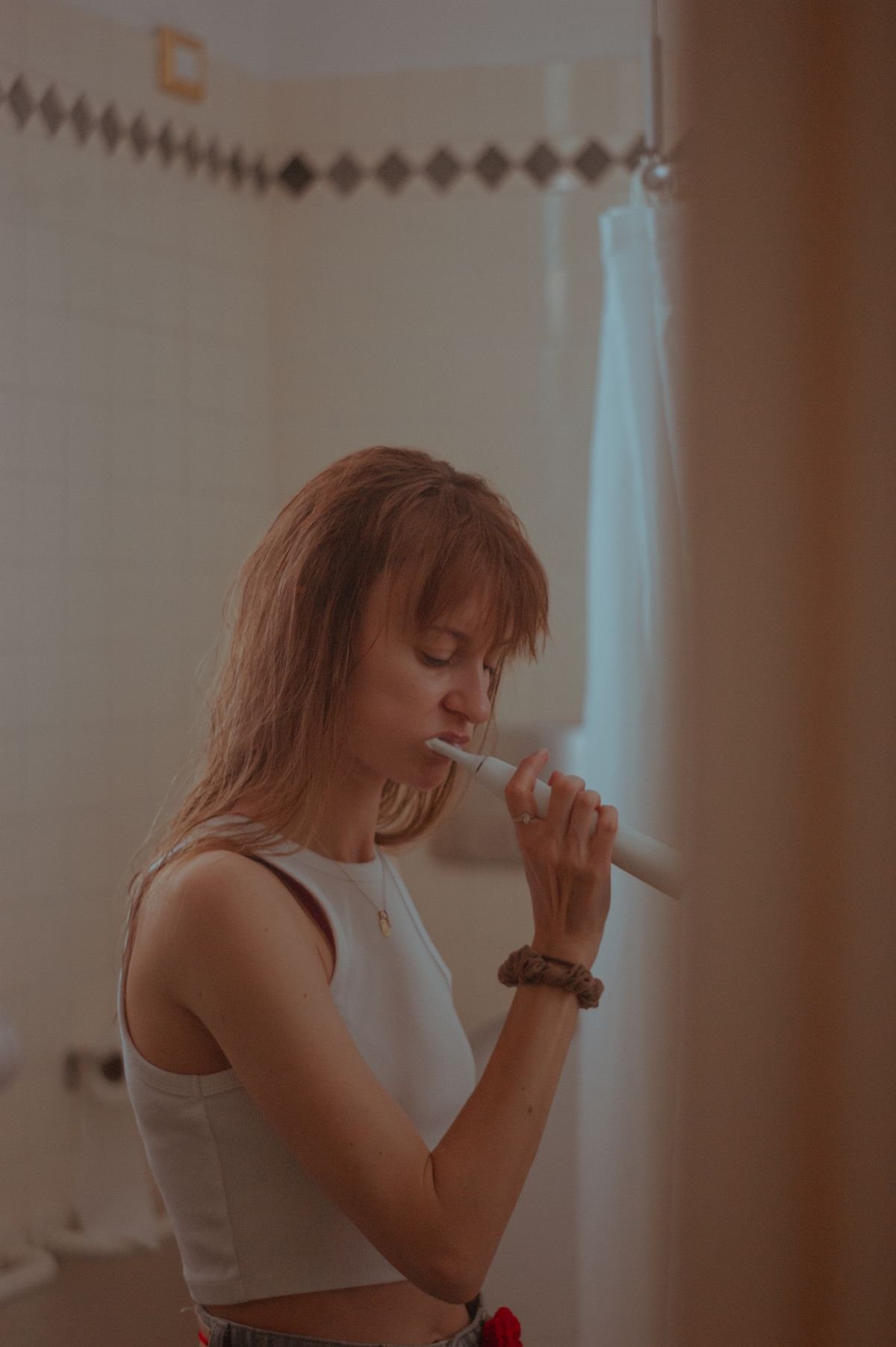 Woman brushing her teeth in the evening as a kitchen closing signal