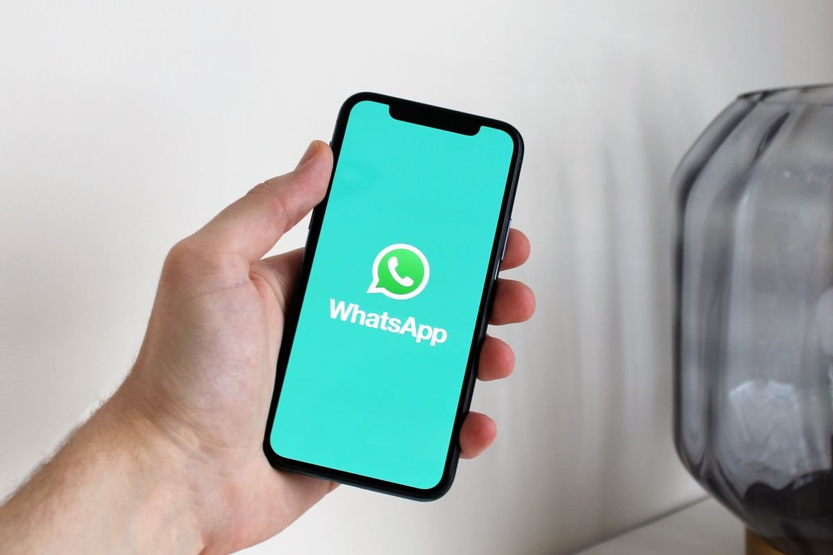 Close up of a hand holding an Android phone with WhatsApp open