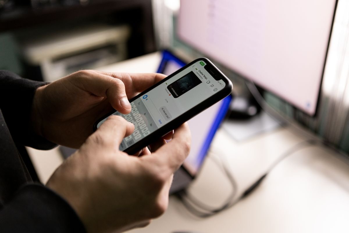 Person using a smartphone to type a chat message indoors