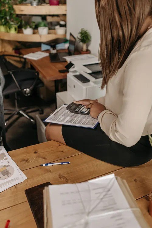 Small business owner using a calculator to review financial documents