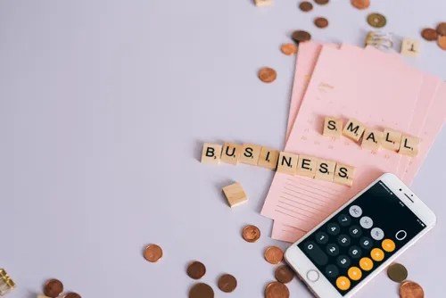 Small business planning flat lay with coins and a calculator