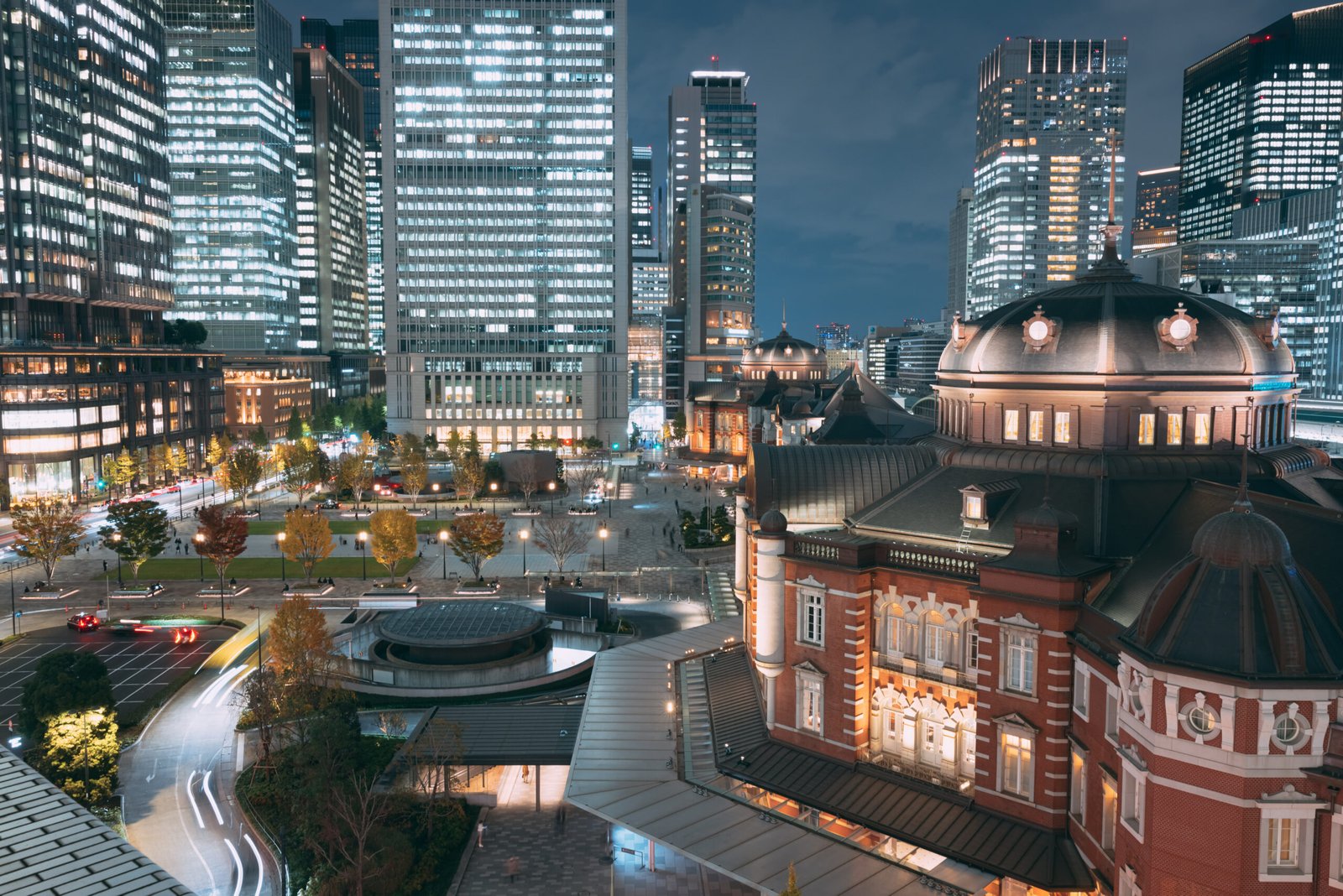 Tokyo Station red brick building at night with city towers