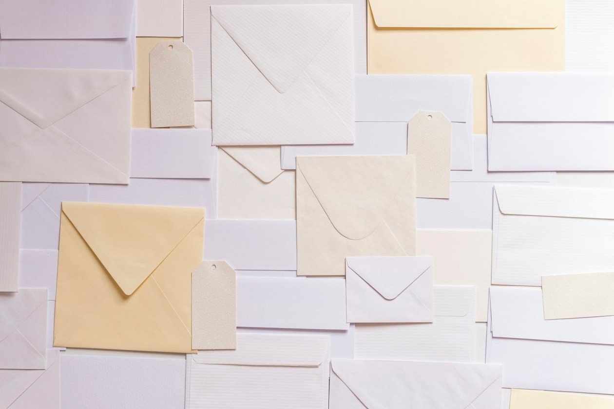 Flat lay of blank white and cream paper envelopes