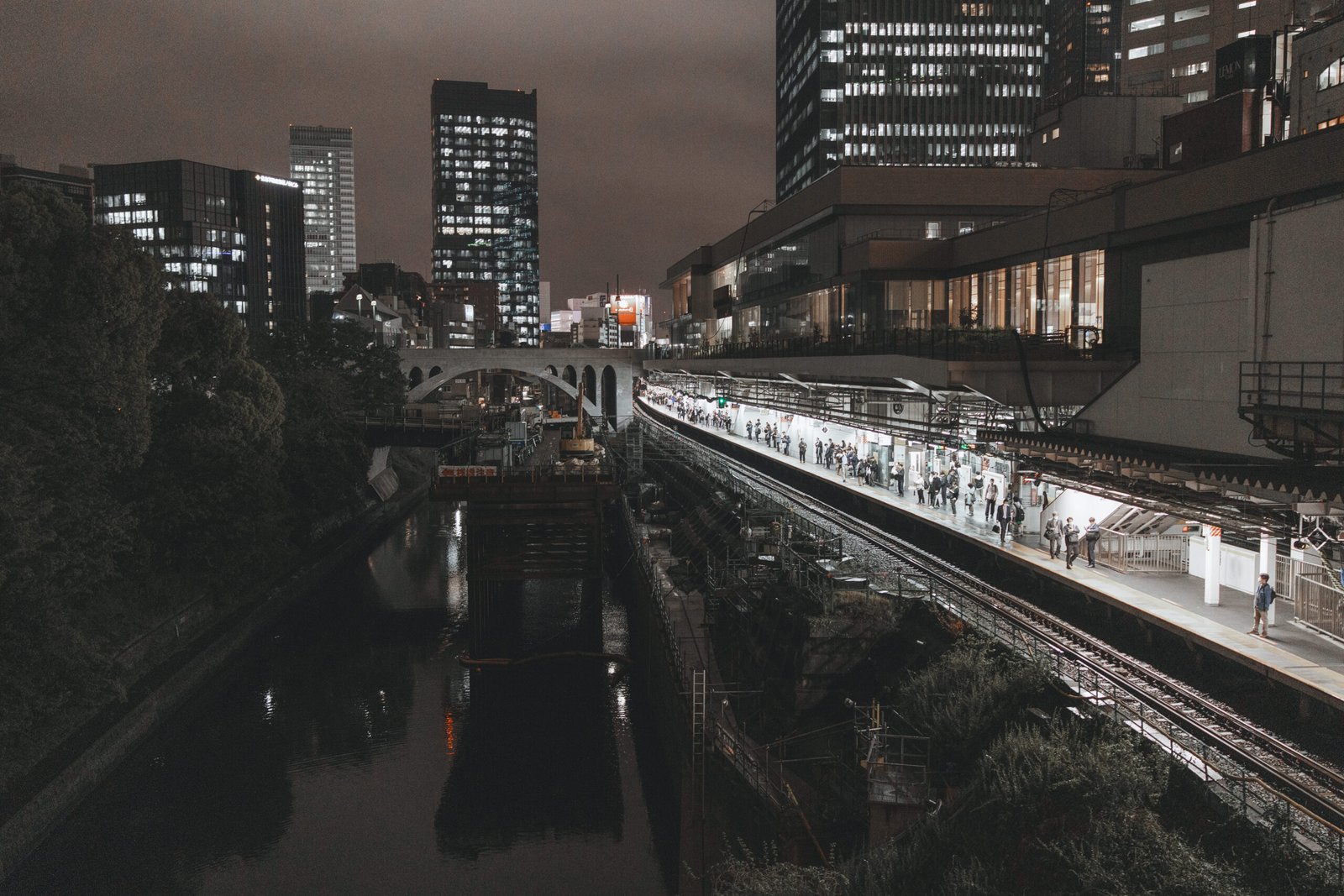 Night view of a Japanese train platform beside a river