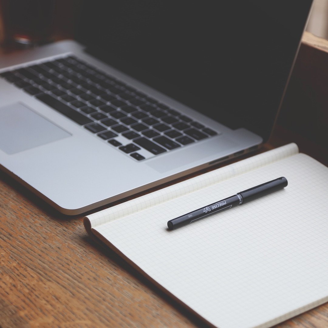 Laptop with notepad used to plan salary negotiation talking points