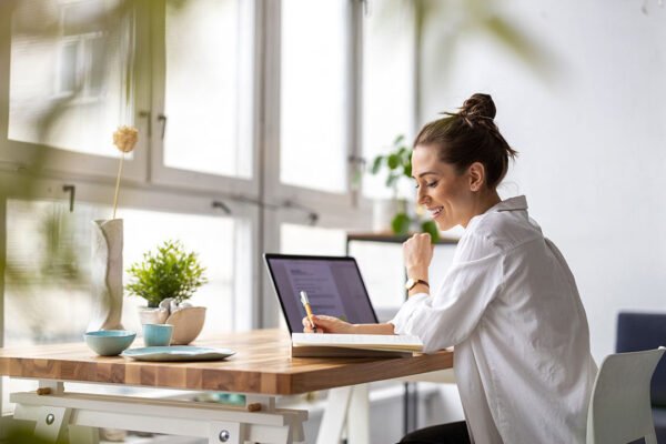 Small business owner writing emails on a laptop at her desk