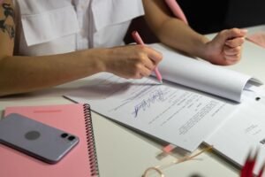 Small business owner writing an employee handbook draft on paper