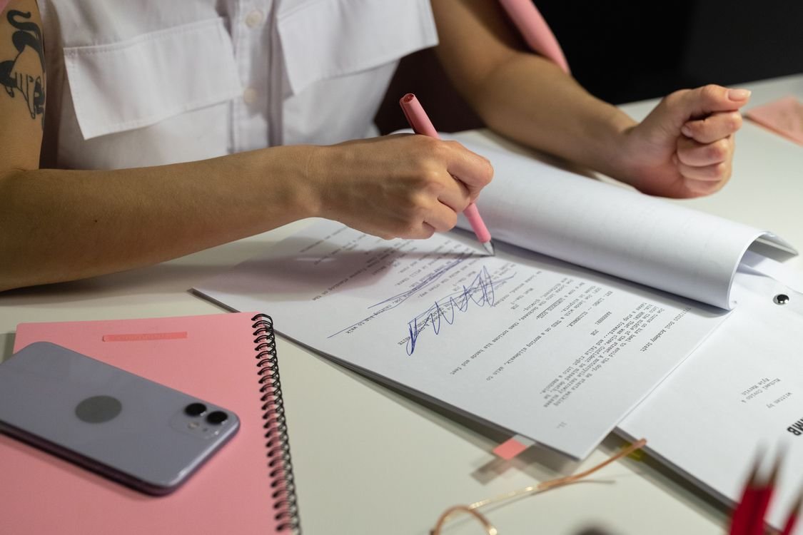 Small business owner writing an employee handbook draft on paper