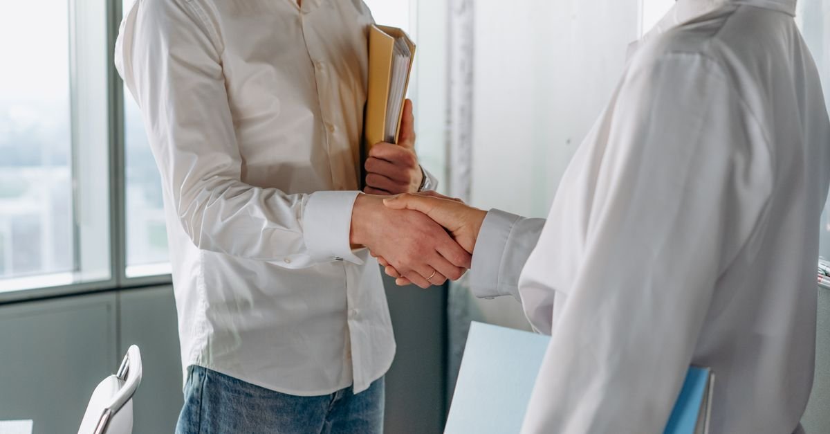 Business owner shaking hands with a client in a bright modern office