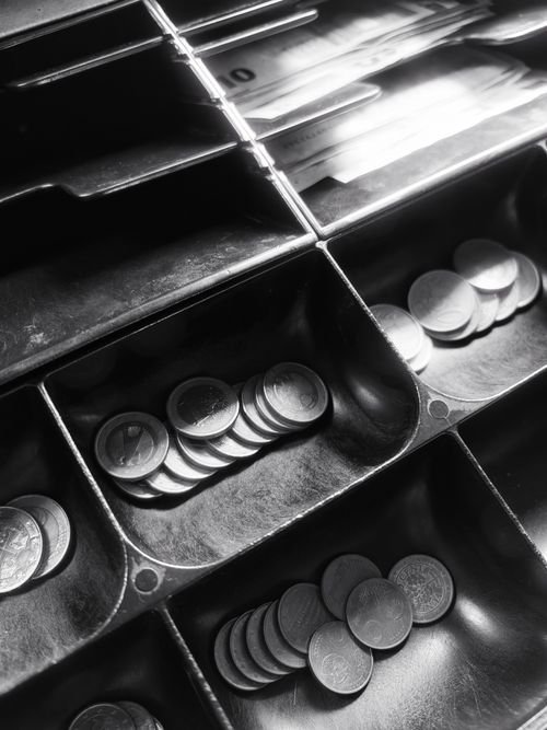 Open cash register drawer with coins and notes ready to be counted