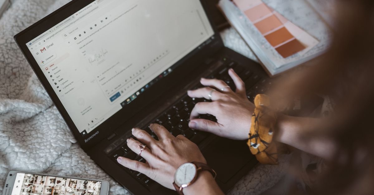 Freelancer typing a follow up email on a laptop