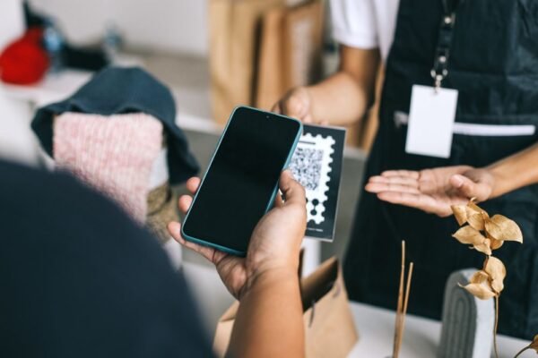 Customer scanning a QR code on a shop counter with a smartphone