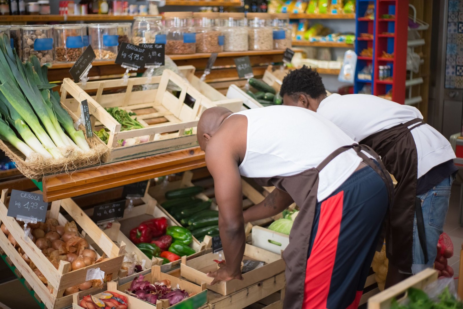Two small shop workers sorting stock in wooden crates
