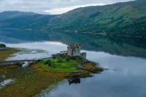 Eilean Donan Castle on a calm loch surrounded by green hills in the Scottish Highlands