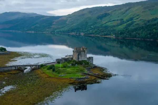 Eilean Donan Castle on a calm loch surrounded by green hills in the Scottish Highlands