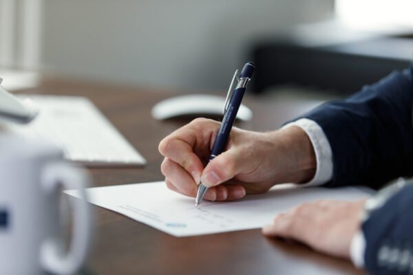 Professional writing a resignation letter by hand at a desk