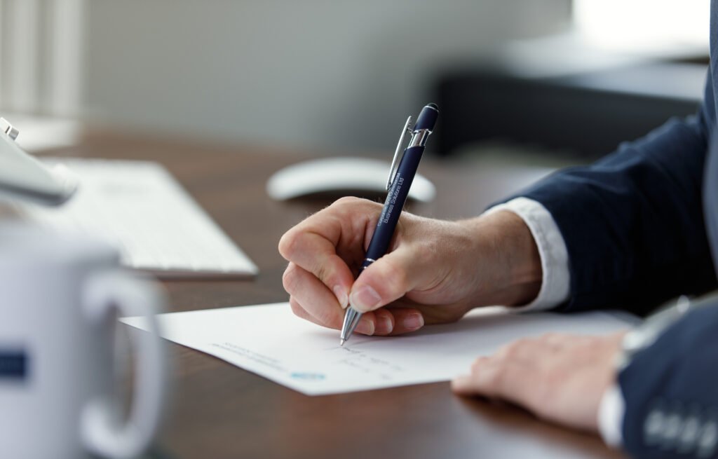 Professional writing a resignation letter by hand at a desk