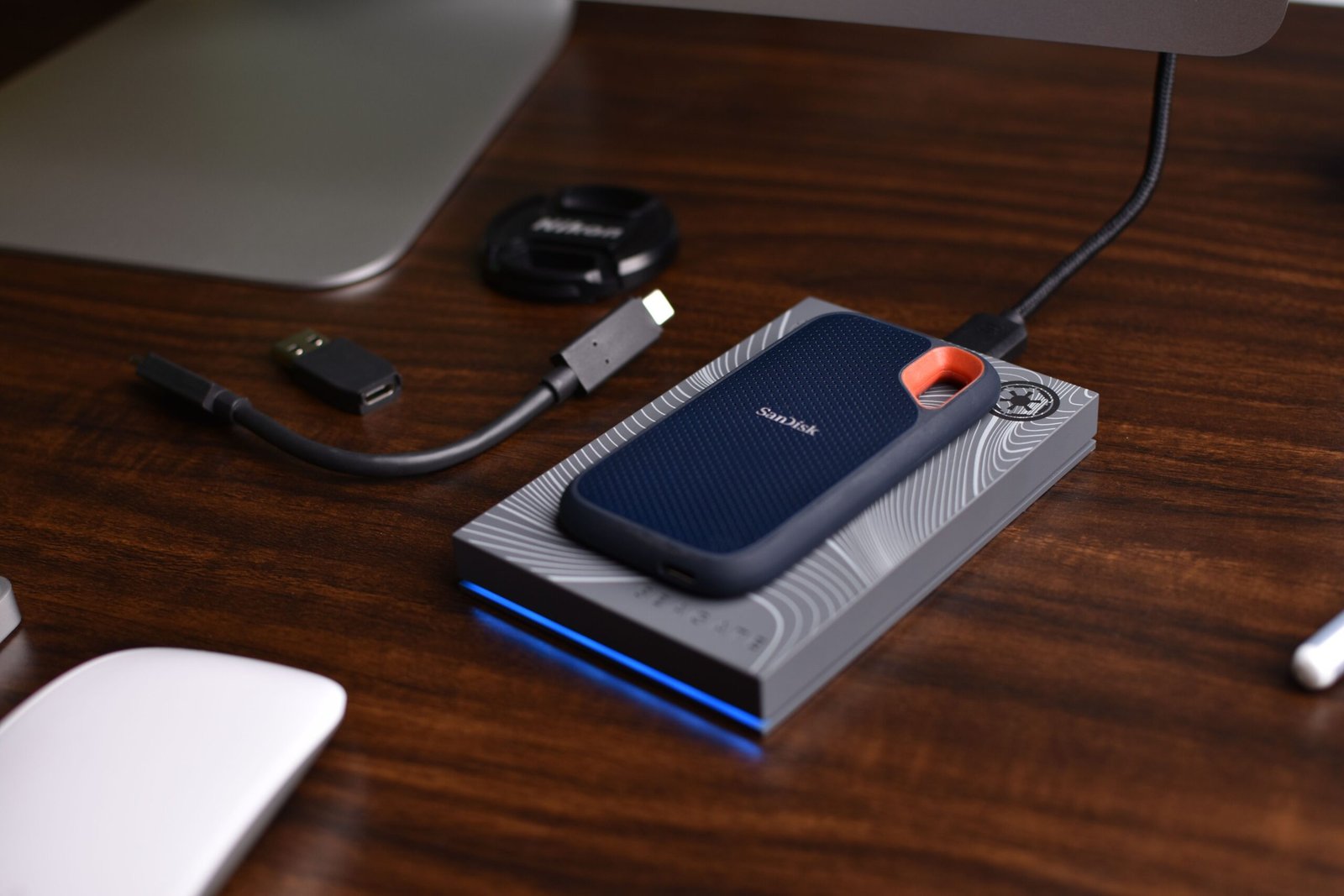 External SSD storage drive with USB cable on a wooden desk ready for automatic business file backup