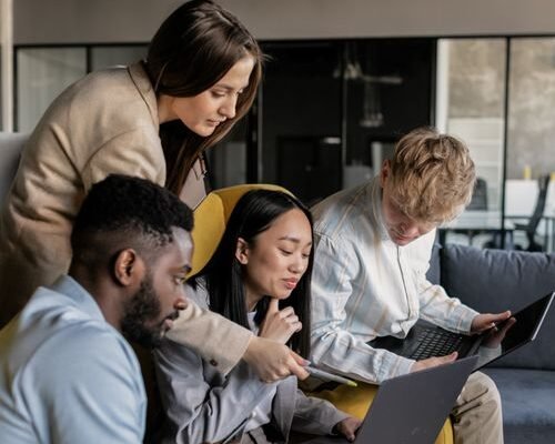 Small business team gathered around a laptop planning their password manager rollout