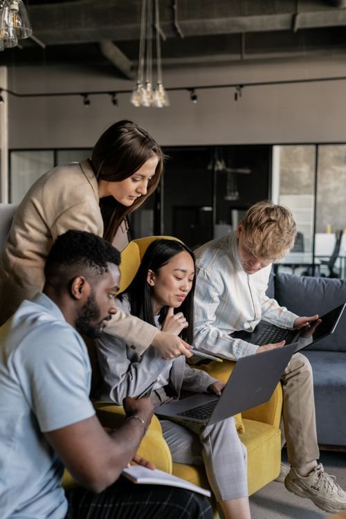 Small business team gathered around a laptop planning their password manager rollout