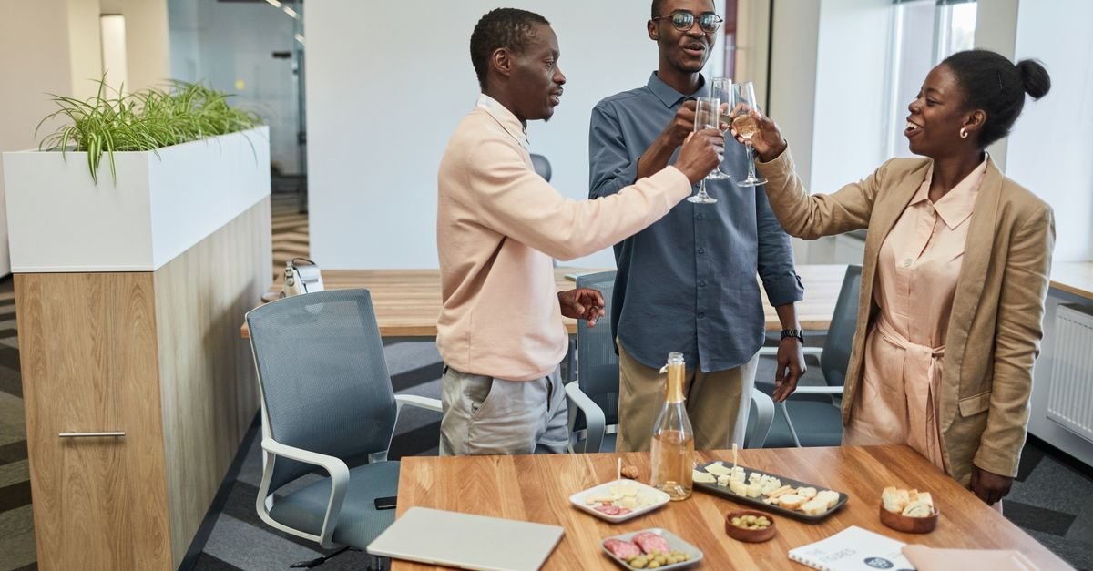 Colleagues raising their glasses in a toast at a small office staff party