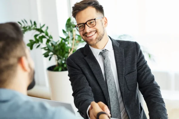 Small business owner shaking hands with their first employee on their first day in the office
