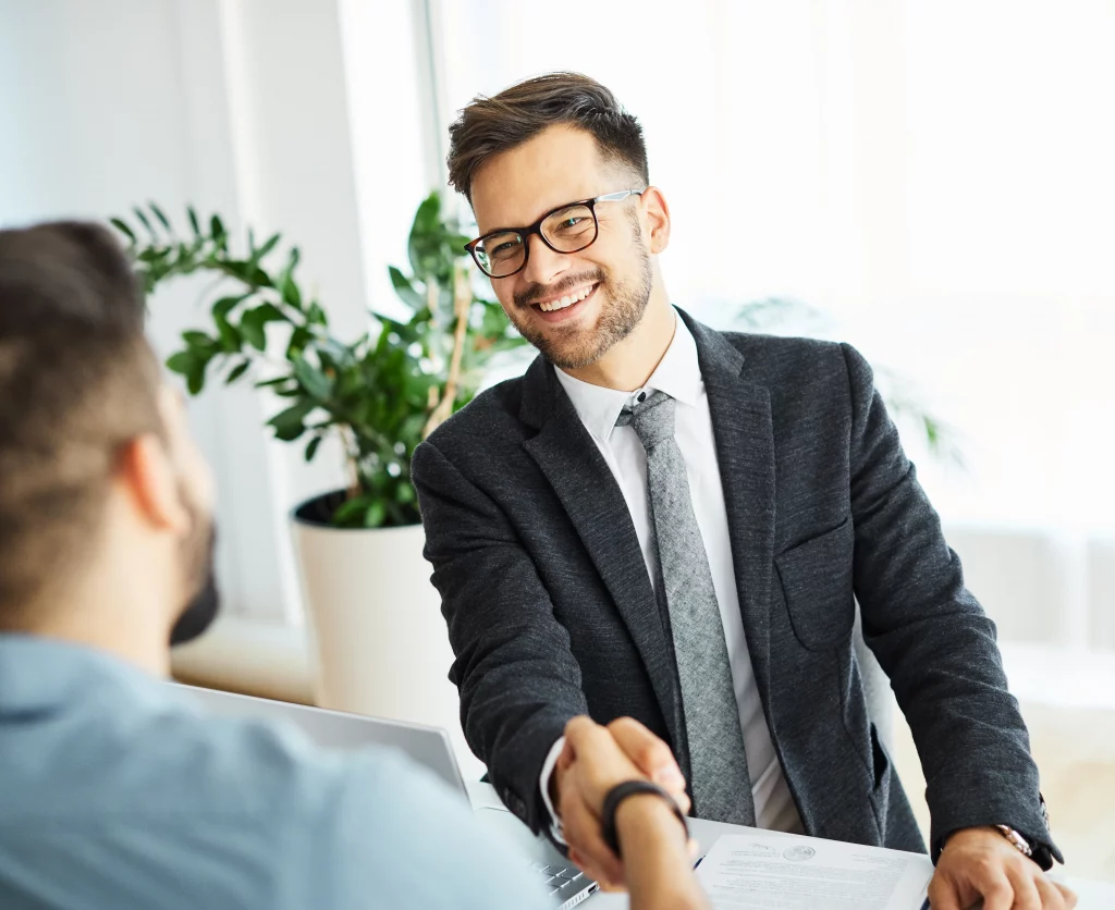 Small business owner shaking hands with their first employee on their first day in the office