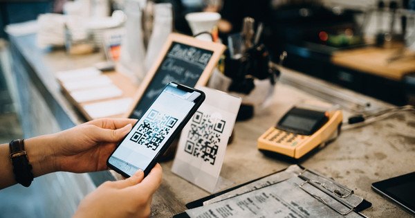 Close up of a hand scanning a QR code with a phone camera