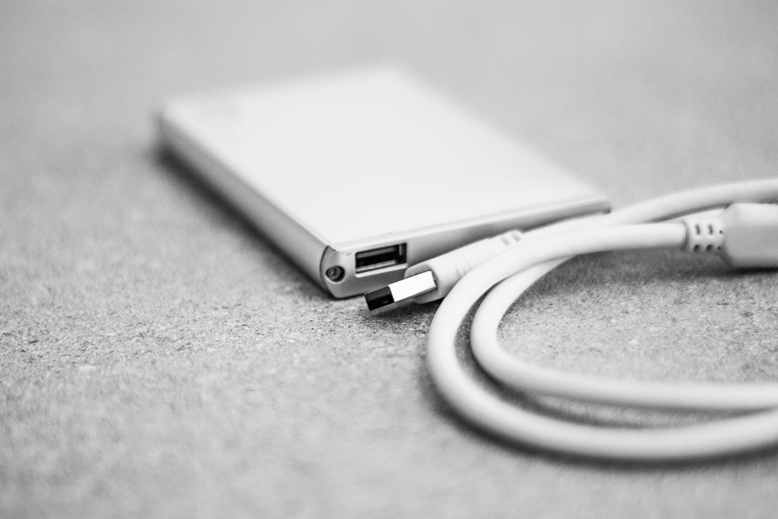 Close up of an external hard drive connected by USB cable for local business file backups
