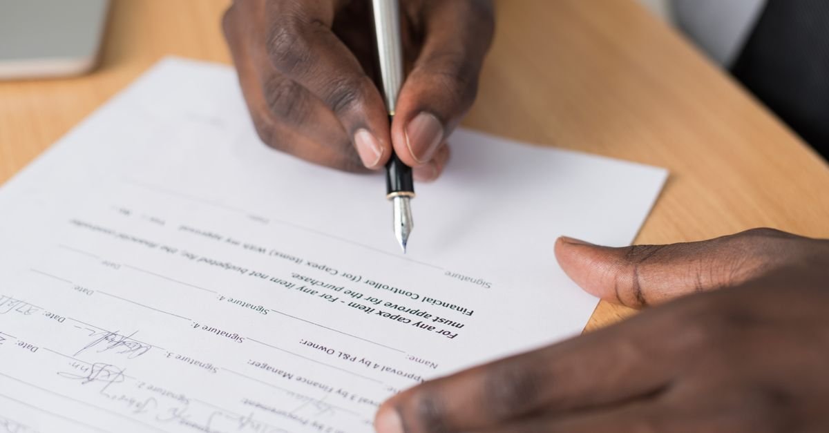 Business owner signing a contract document with a fountain pen