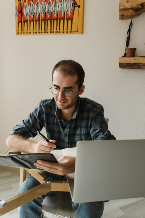 Business owner planning the password manager rollout with a notebook and laptop
