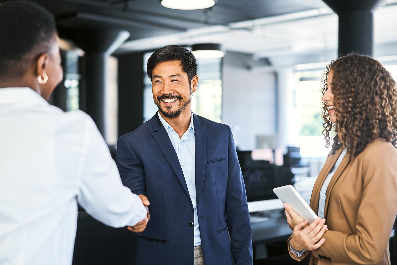 Business colleagues shaking hands goodbye at the office
