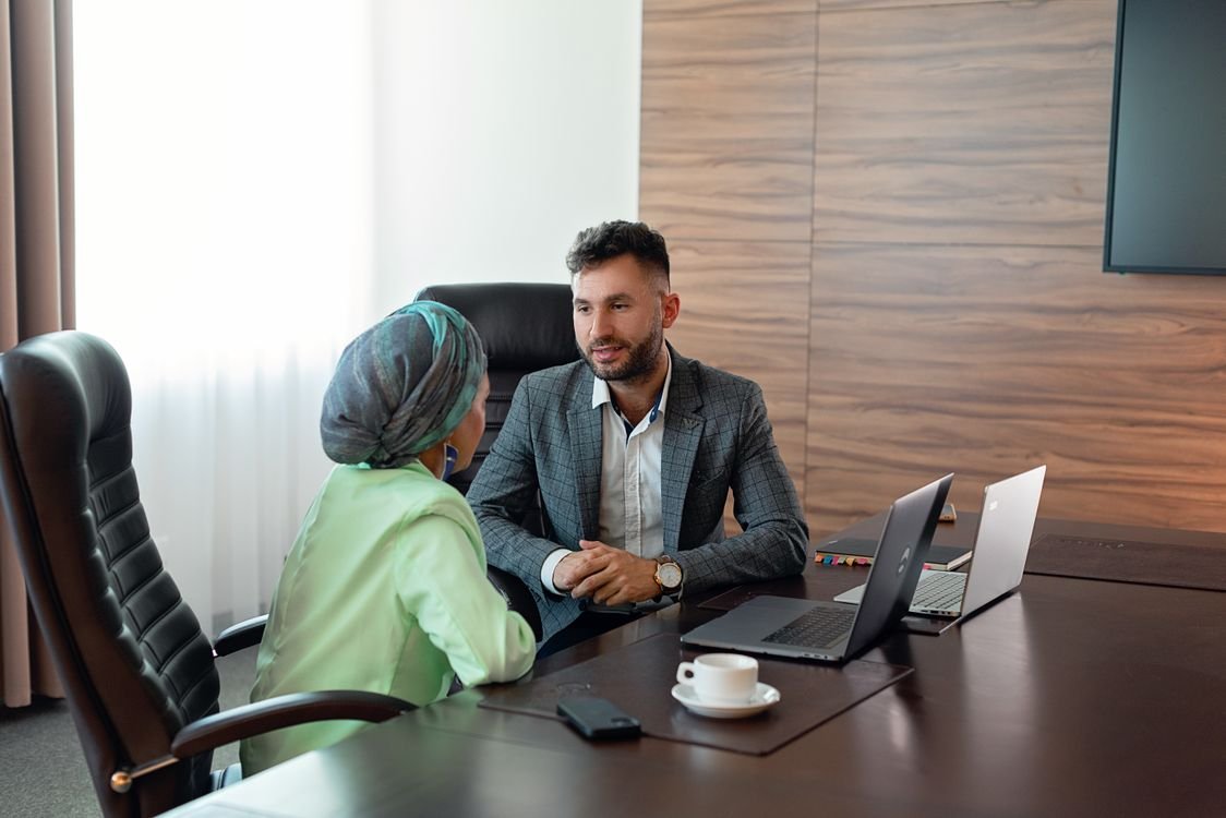 Manager speaking with an employee in a relaxed office setting during a one to one meeting