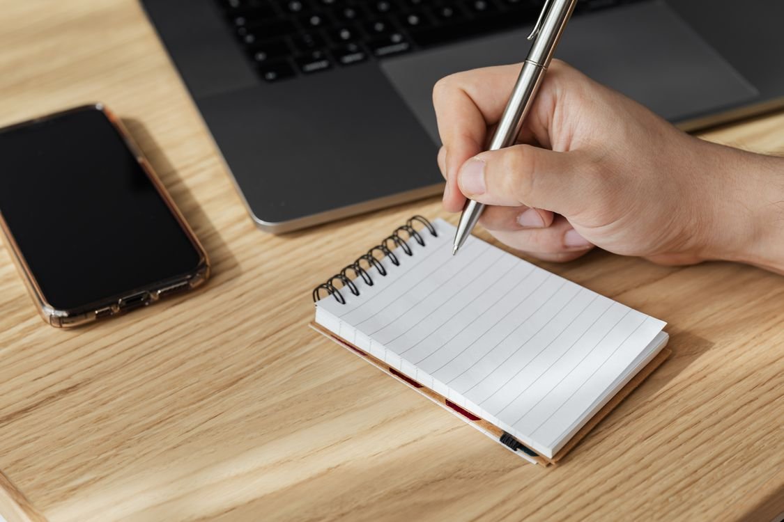 Open notebook and pen on a desk ready for taking exit interview notes