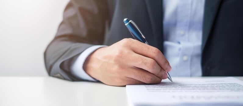 Business person signing a formal final demand letter with a pen