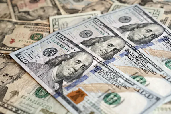 Close up of US dollar bills stacked in a pile