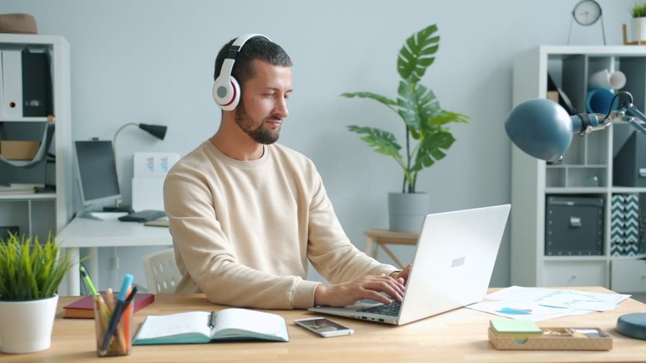 Small business owner writing an email on a laptop at a desk