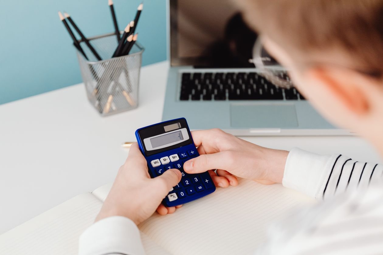Person using a calculator and notebook to work out freelance rates