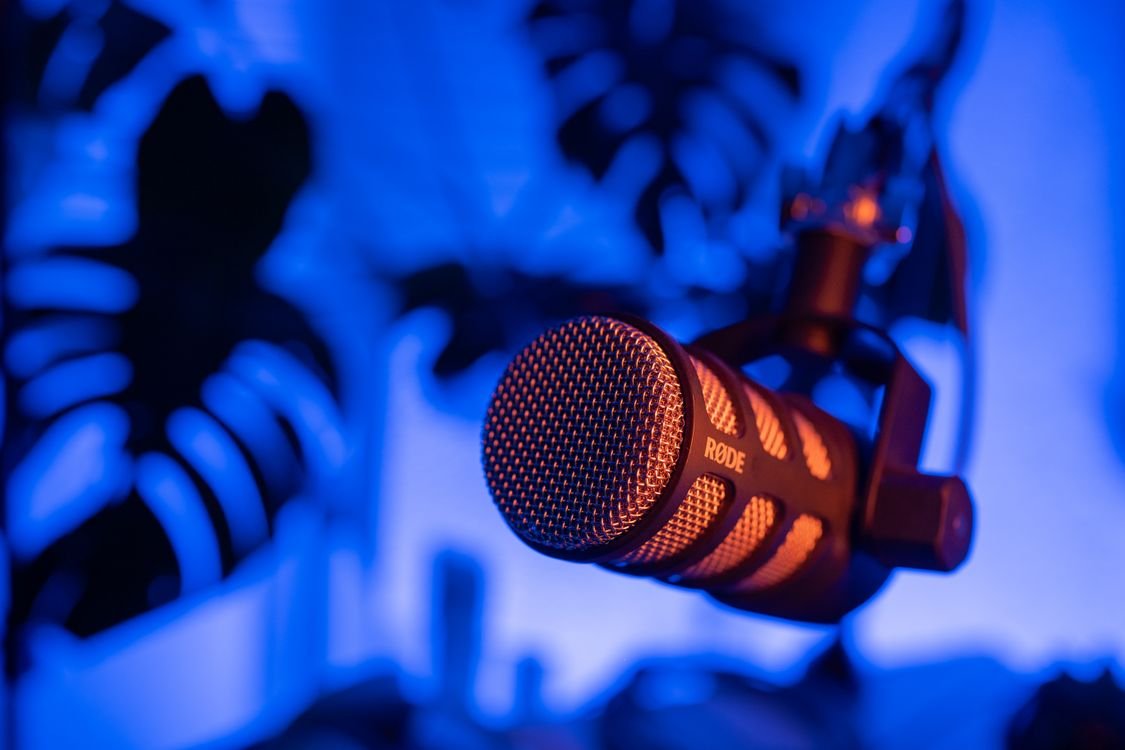 Close view of a microphone glowing under blue studio light