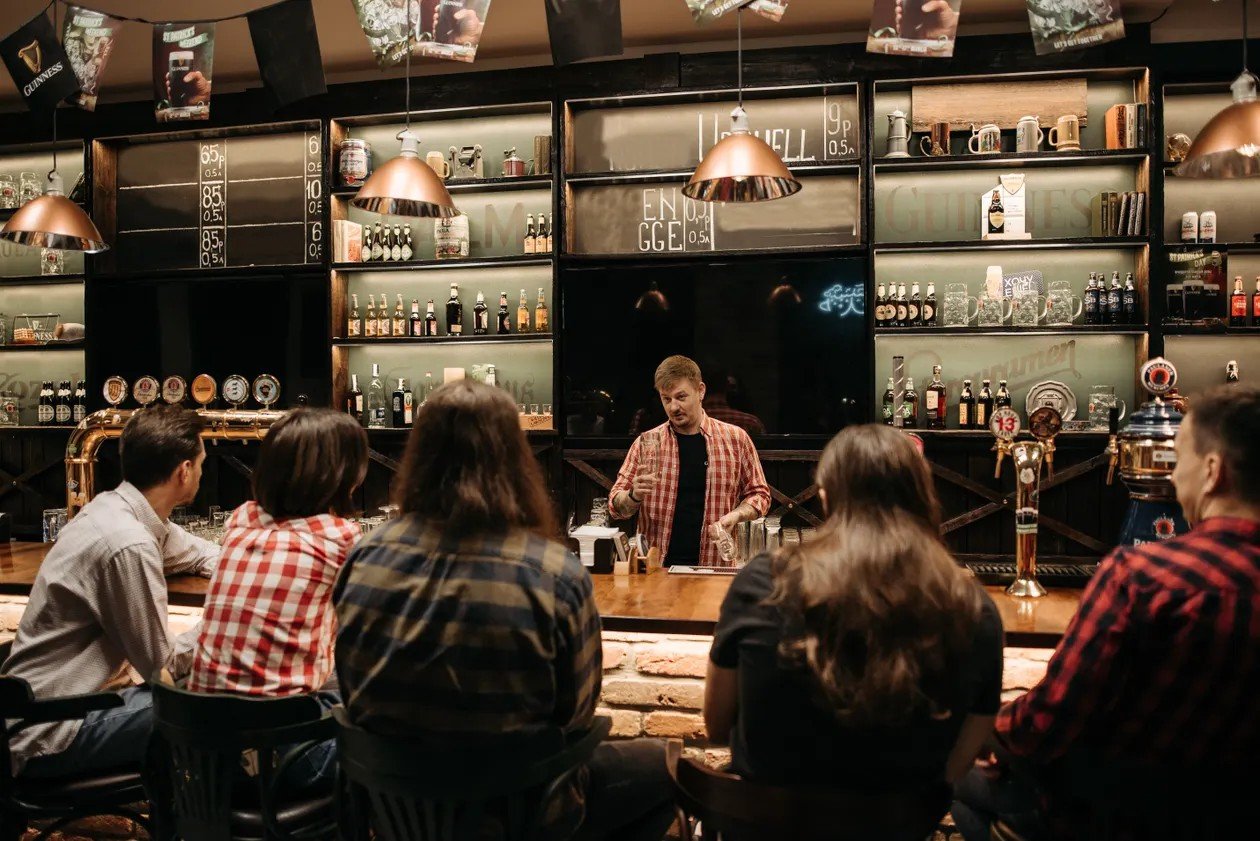Bar host talking to customers from behind the bar during a pub quiz night