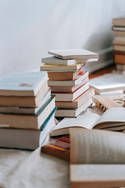 Stack of colorful books waiting on a wooden table