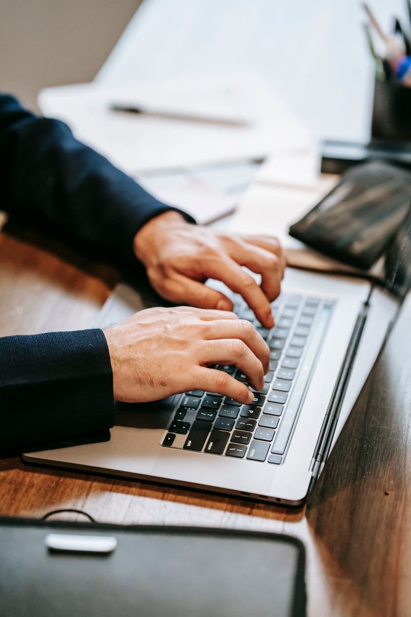 Close up of hands typing an email on a laptop keyboard
