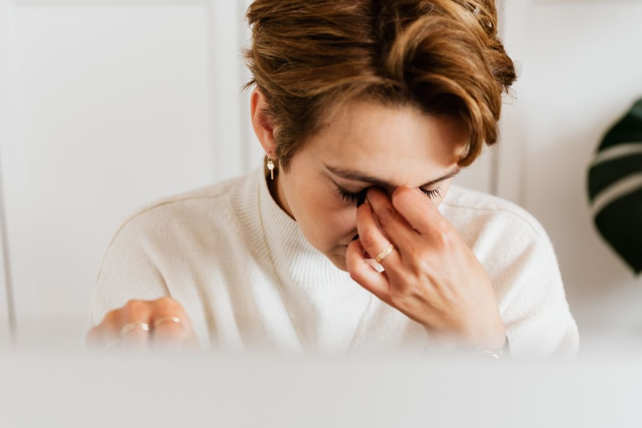 Close up of a woman rubbing her tired eyes from stress and fatigue