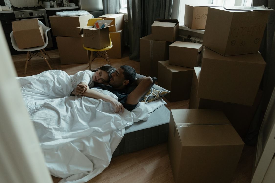 Bedroom piled high with cardboard boxes showing a spare room turned into a junk room