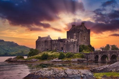 Eilean Donan Castle glowing at sunset above the water in the Scottish Highlands