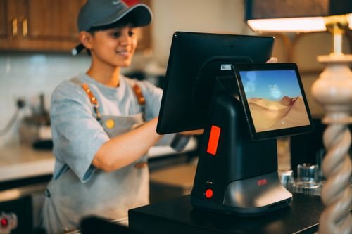Cashier using a modern point of sale terminal in a shop