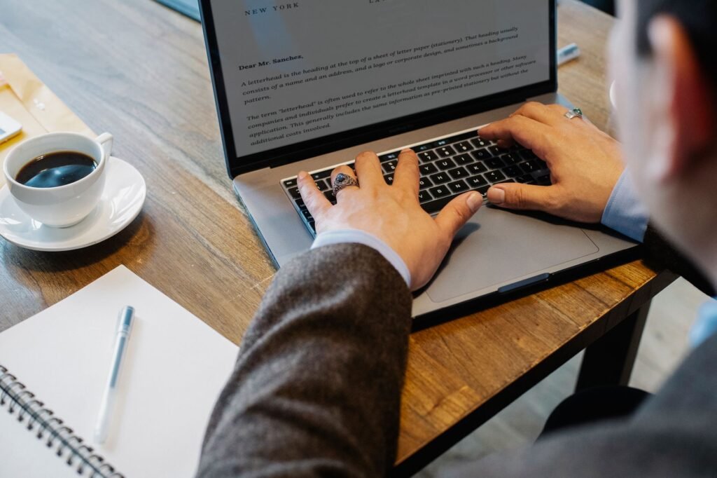 Writing a professional client email on a laptop at a desk