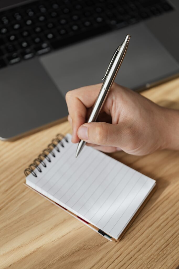 Hand writing stock count notes in a notebook