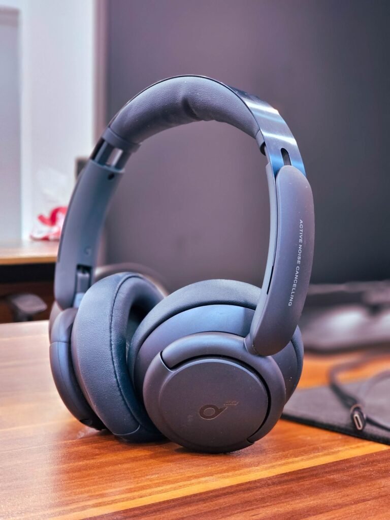 Active noise cancelling headphones resting on a wooden office desk