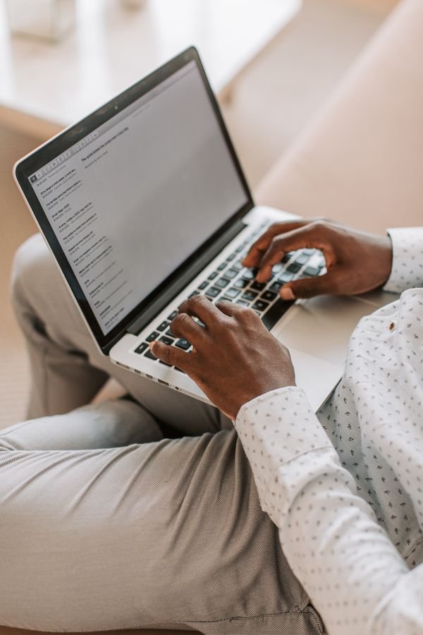Freelancer typing a client email reply on a laptop keyboard